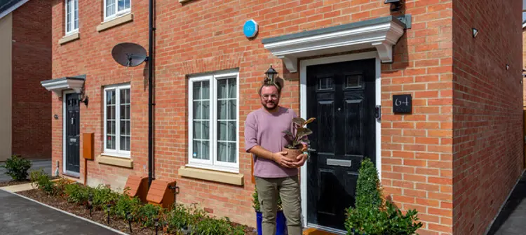 Man holding plant outside house