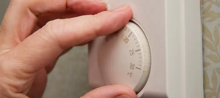 Hand on thermostat