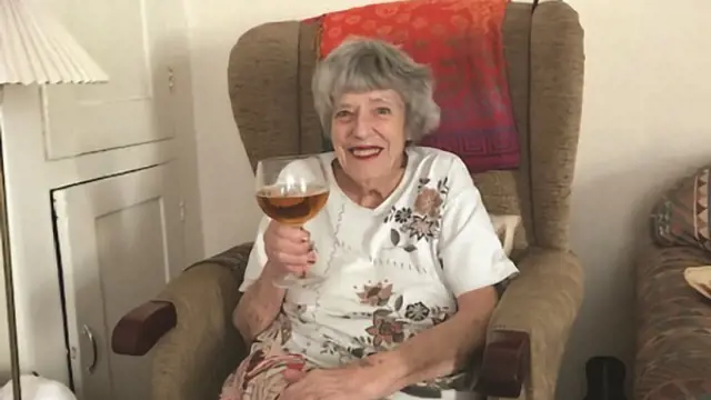 Woman sitting in a chair and holding a glass