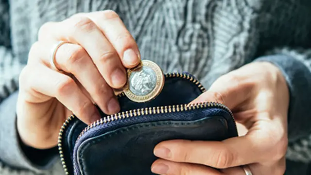 Hands putting coins in purse