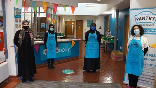 Women standing and wearing blue aprons