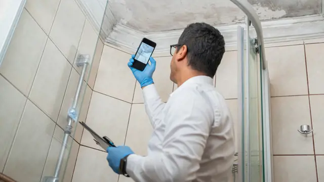 Man photographing mould in a bathroom