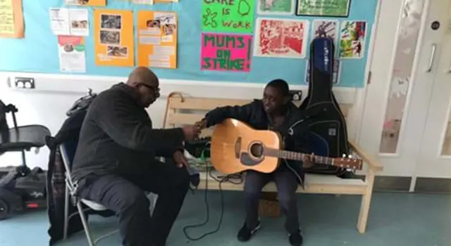 Man and child playing guitar